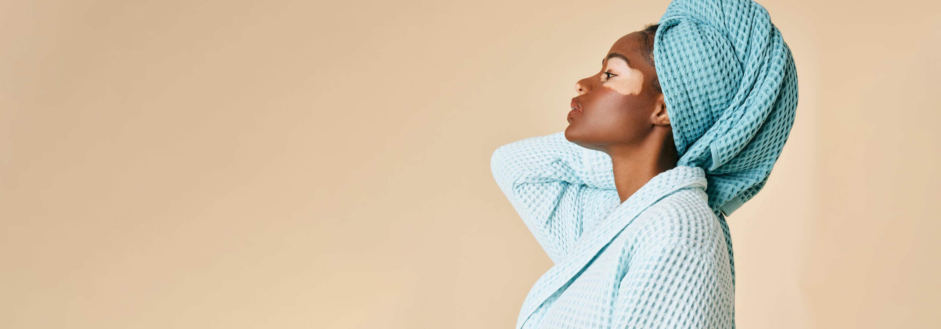 Brooklinen: Woman with vitiligo wearing Brooklinen towel and robe